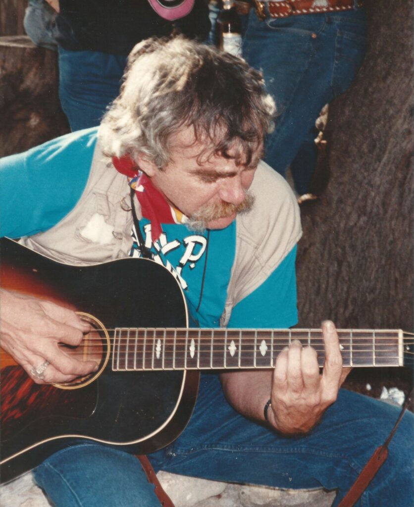 Frank playing guitar in turquoise shirt